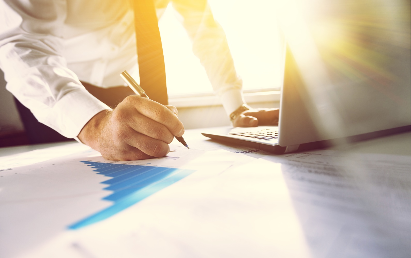 Мужчина в галстуке заполняет документы